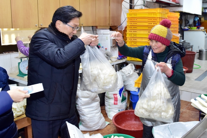백운석 수원시 제2부시장이 정자시장에서 떡국떡을 구입하고 있다.