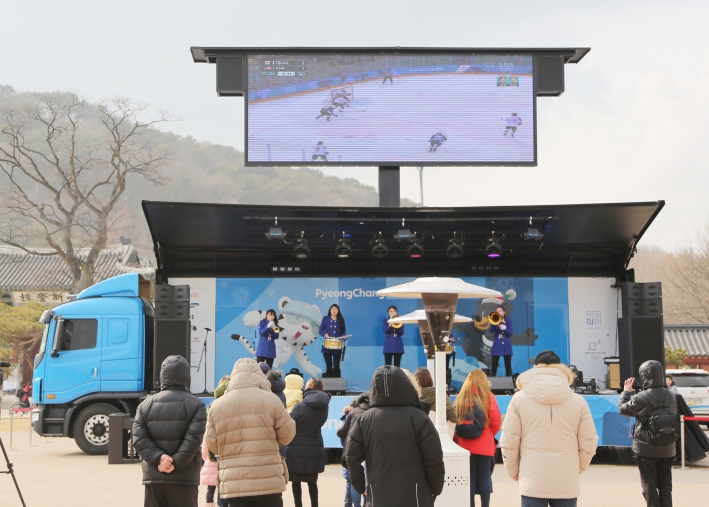 시민들이 화성행궁 광장에 설치된 '라이브사이트'에서 차량에 설치된 대형 스크린을 통해 올림픽 경기를 관람하고 있다.