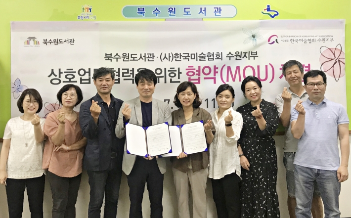 수원시북수원도서관과 한국미술협회수원지부가 '상호 업무협력을 위한 협약'을 체결한후 기념촬영을 하고 있다. 