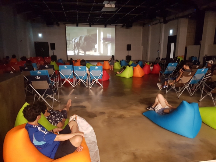 매트위에서 자유스러운 분위기에서 영화를 즐기고 있는 시민들 