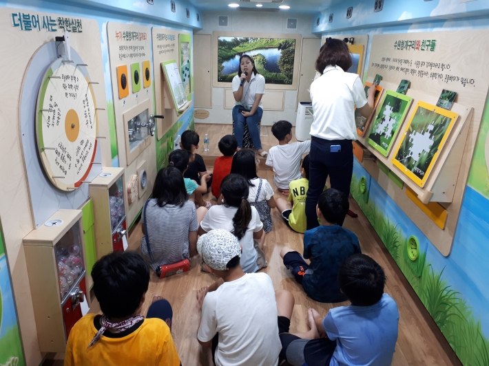 참가 아동들이 환경버스에서 강사의 설명을 듣고 있다.