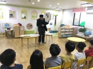 아이들에게 만화를 통한 인성교육 중인 권영섭(한국원로만화가협회 회장)과 어린이집 아동