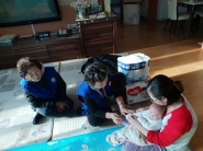 다문화가족에 출산 축하선물 전달한 후 한국에서의 자녀 양육방법에 대해 설명하고 있다. 