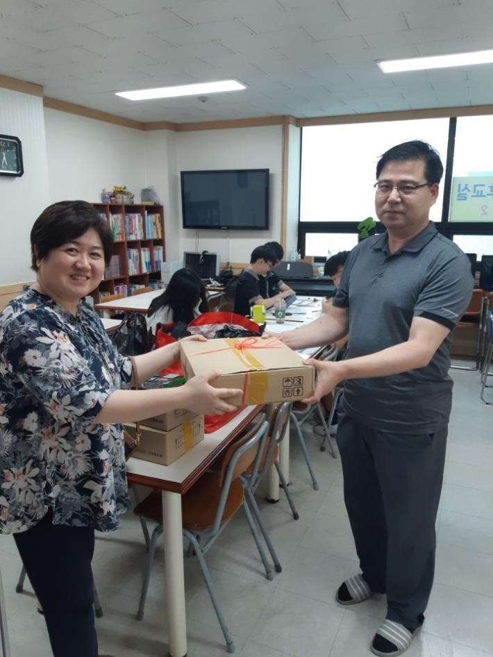 영통구 가정복지과 김미현 팀장이 망포새힘 지역아동센터를 방문하여 종사 직원과 이용 아동에게 후원품을 전달하고 있다.