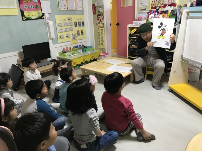 권영섭 회장이 캐릭터를 가지고 아이들과 소통하는 장면