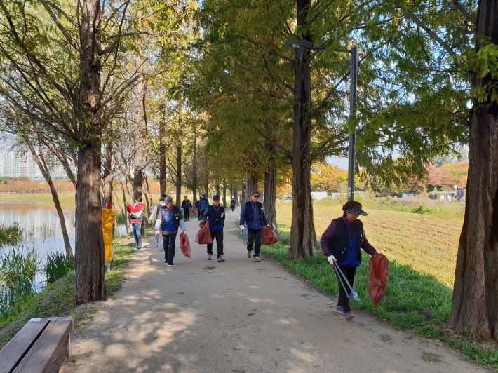 시민들이 일월공원에서 '공원 클린데이' 행사에 참여해 쓰레기를 수거하고 있다.   