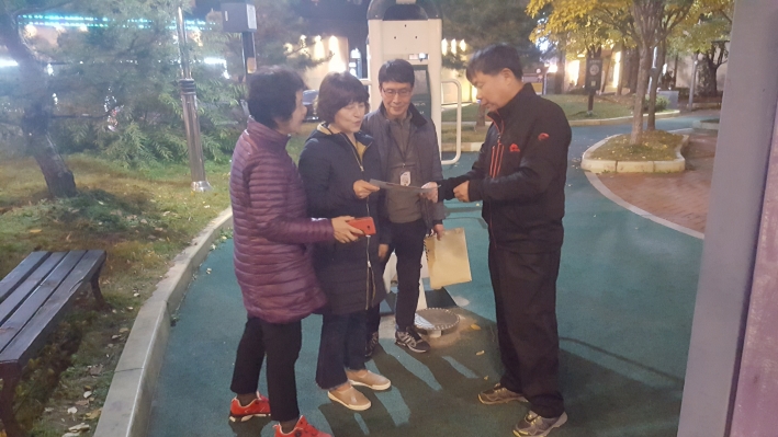 신곡어린이 공원 앞에서 인근 주민에게   쓰레기 분리 배출안내 홍보물을 건네주며 홍보활동