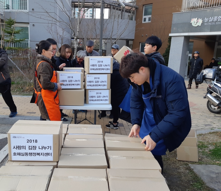 신협직원들이 동김장 나눔 봉사활동에 참석해 어르신들에게 김장을 배달하고 있다.