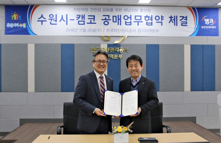이택용 수원시 경제정책국장(오른쪽)과 김구영 한국자산관리공사 경기지역 본부장(왼쪽)이 협약을 체결하고 기념촬영을 하고 있다.