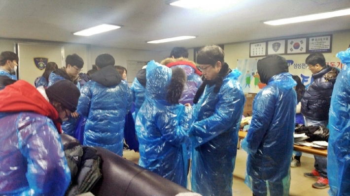 지동기동순찰대 사무실에서 연탄을 나르기 위해 비닐우의 등으로 환복을 하는 봉사자들