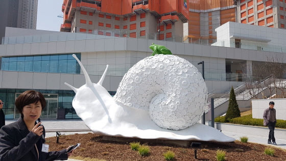 야외에 설치되어 있는 '달팽이와 청개구리'앞에서 작품을 설명하는 조혜영 전시팀장 모습