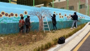마을만들기협의회 회원들이 벽화를 그리고 있다