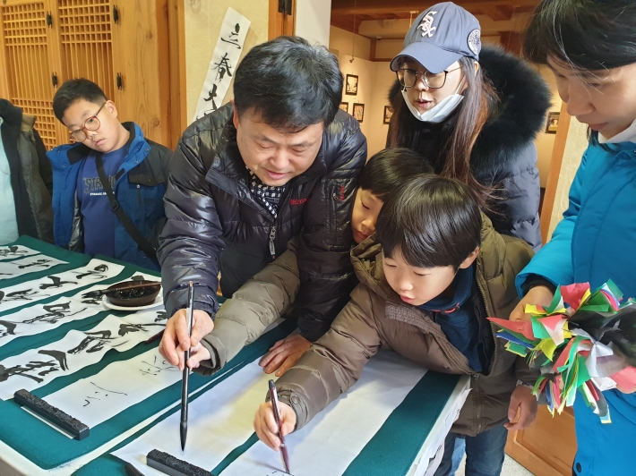김영훈 지부장이 아이들에게 입춘방 쓰기 체험을 돕고 있다. 