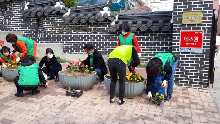골목길 마을정원에 봄꽃을 식재하는 단체회원들