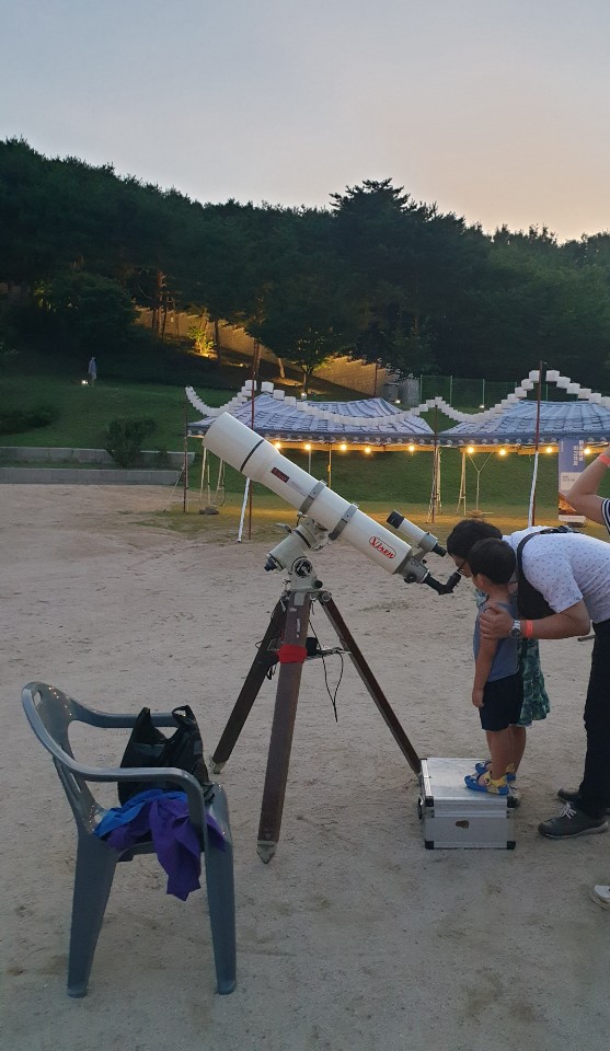 망원경으로 달을 보고 있는 아빠와 아이들
