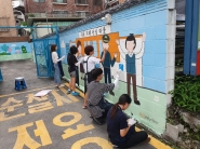 KT&G 상상 Univ 17기 자원봉사단이 지동 치매안심마을에 치매친화적 환경조성을 위해 벽화를 그리고 있다