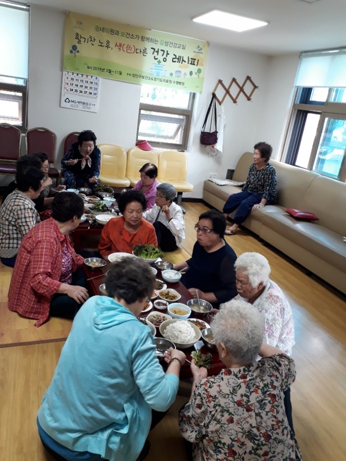 연무경로당 노인들이 둘러앉아 식사하고 있다.