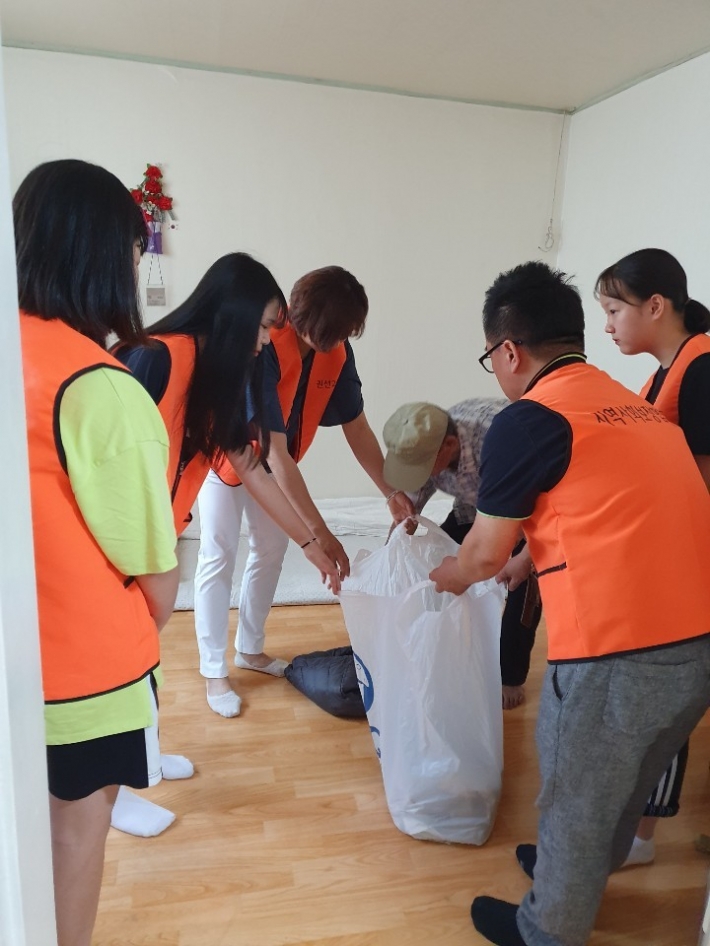 청소년자원봉사자 3명과 지역사회보장협의체 위원들이 함께 세탁물을 수거하고 있다. 