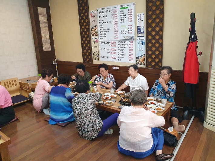 권선1동 어르신들이 두부가 식당에서 서로 이야기를 나누며 식사를 하시고 있다.