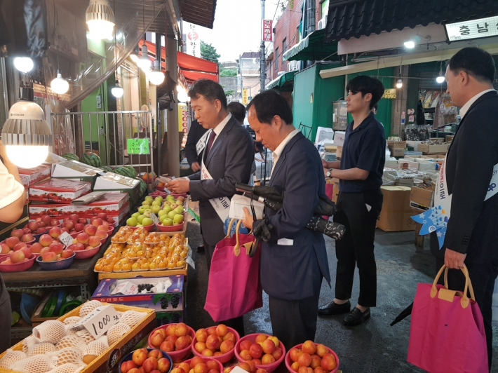 과일을 구매하면서 온누리 상품권으로 결재하는 백운만 경기지방중소벤처기업청장(왼쪽)
