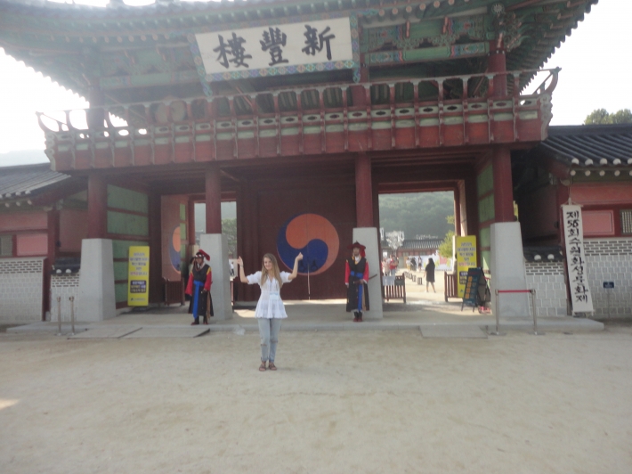 외국인 여성관광객이 신풍루 수문장을 배경으로 기념사진 포즈를 취하고 있다.