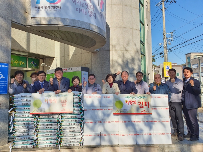 SKC수원공장이 정자1동에 김치 300박스와 쌀 100포를 기부한 후 기념촬영을 하고 있다. 
