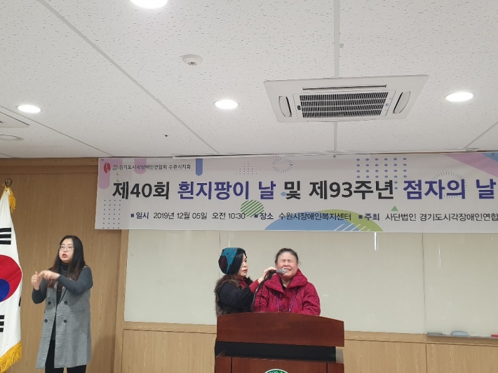 박순자 회원 대표가 조정아 수어(手語)통역사의 도움을 받으며  '흰지팡이 헌장'을 낭독하고 있다