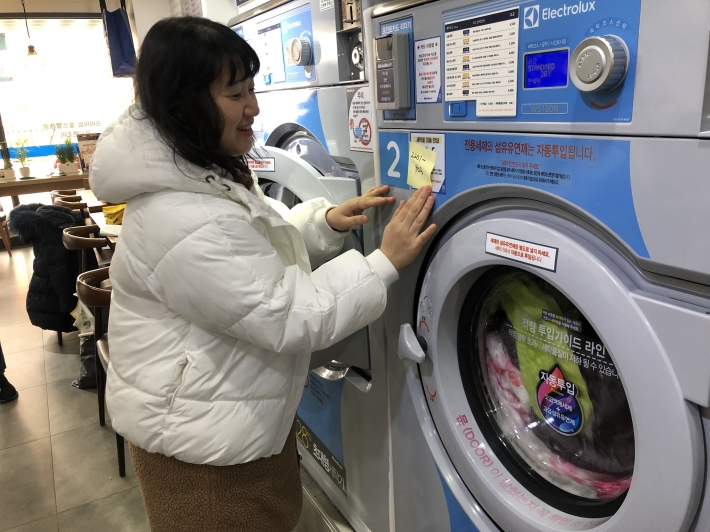 호매실동 지역사회보장협의체 의원이 세탁기로 이불빨래를 하고 있다. 