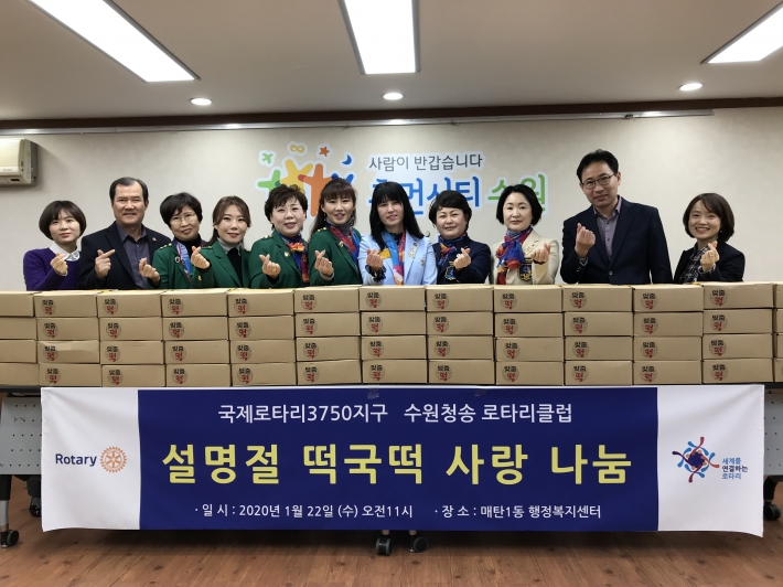 수원청송로타리클럽이 매탄1동 행정복지센터를 찾아 사랑의 떡국떡을 기부하고 단체로 기념촬영을 하고 있다. 