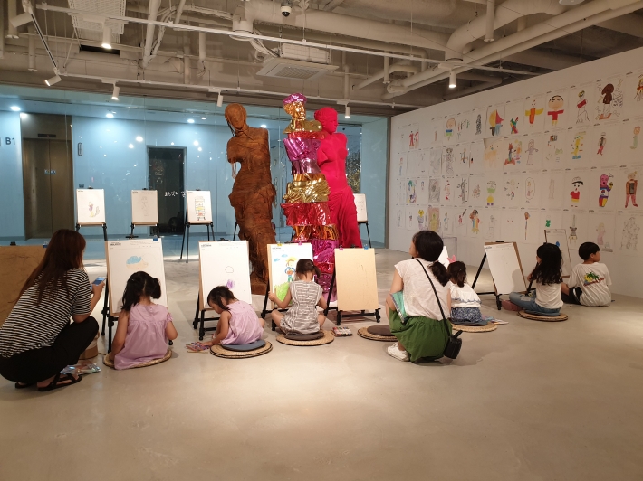 아트스페이스 광교의 '미술실기 체험' 프로그램에 참여하고 있는 어린이들이 진지하다