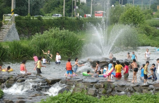 되살아난 수원천에서 아이들이 물놀이를 하고 있다.