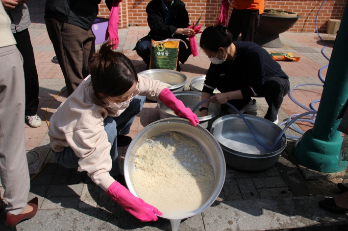 수원시자원봉사센터 관계자와 수원지역 자원봉사단체 관계자들이 '사랑의 밥차' 운영을 앞두고 시험 가동을 위해 쌀을 씻고 있다
