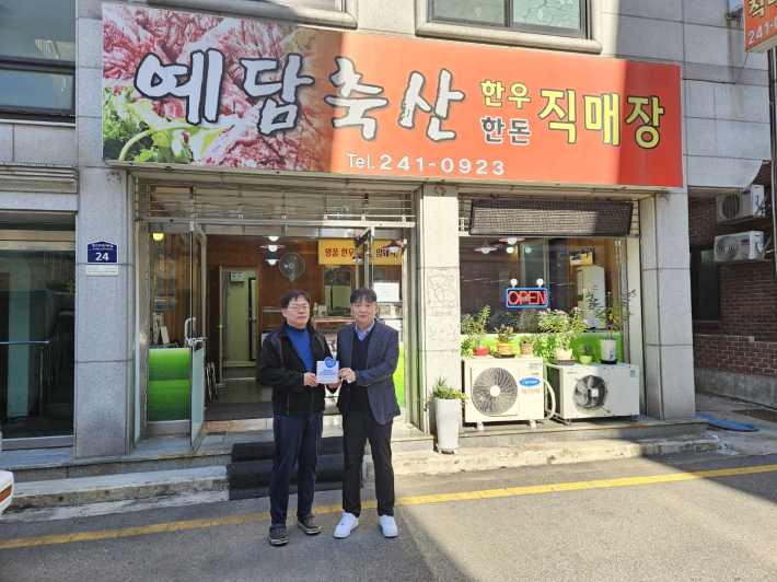 SK청솔노인복지관 관계자 및 김형열 예담축산 사장이 나눔 현판 전달식을 기념하고 있다.