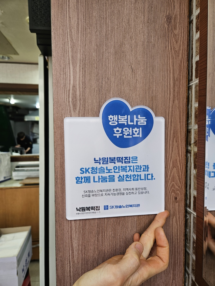 낙원복떡집에 SK청솔노인복지관 행복나눔 후원회 나눔현판이 배치되었다.