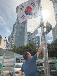 화서1동 새마을지도자협의회원이 태극기를 게양하고 있다.