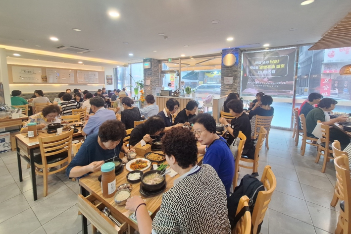 율천동 통장협의회와 환경관리원들이 복달임 식사를 함께하고 있다.