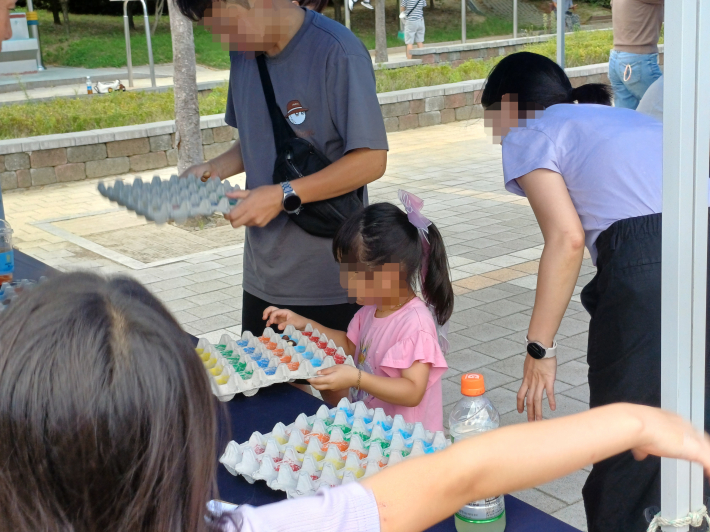 어린이와 엄마·아빠가 달걀 빈 상자를 이용 놀이하는 모습
