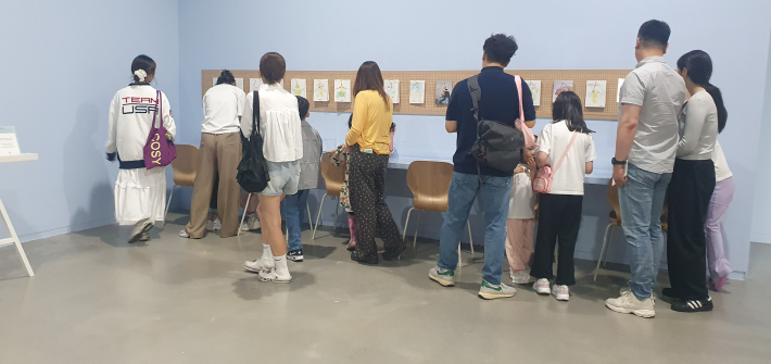 어린이와 가족 관람객들이 전시 연계 공간에서 작품과 자료를 살펴보고 있다. 추석 연휴를 맞아 가족 단위 관람객의 발길이 이어졌다.