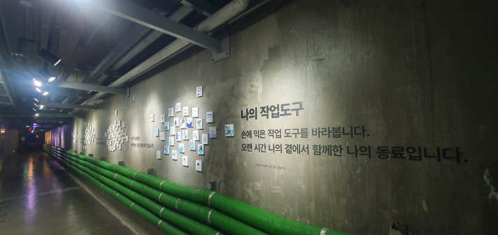 산업시설의 녹색 배관 위로 산업단지 직원들이 그린 '나의 작업도구' 그림이 이어진다. 오랜 시간 손에 익은 작업도구를 통해 산업현장에서 일하는 사람들의 이야기를 전한다.
