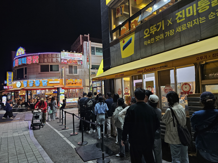 통닭을 맛보기 위해 가게 밖까지 길게 줄을 선 시민들