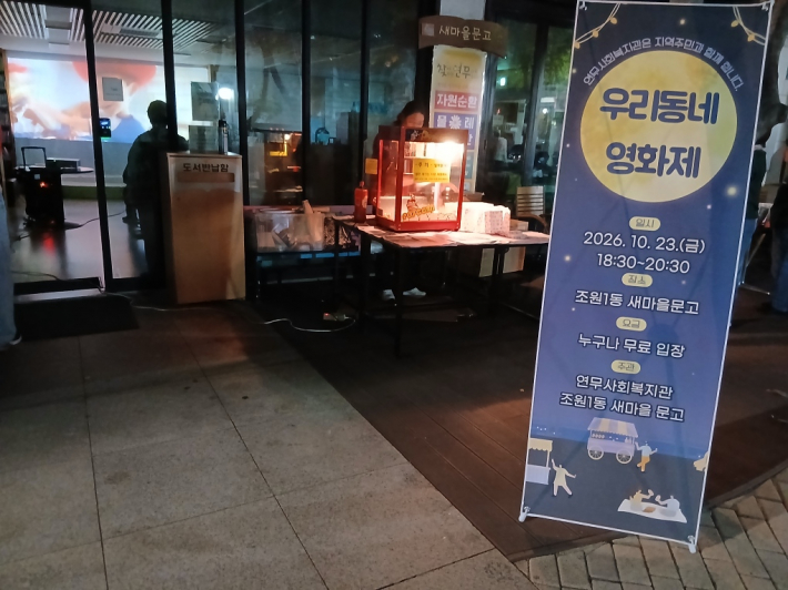 영화 상영에 맞춰 문고 회원이  문고 앞에서 팝콘과 음료를 준비하고 있다.