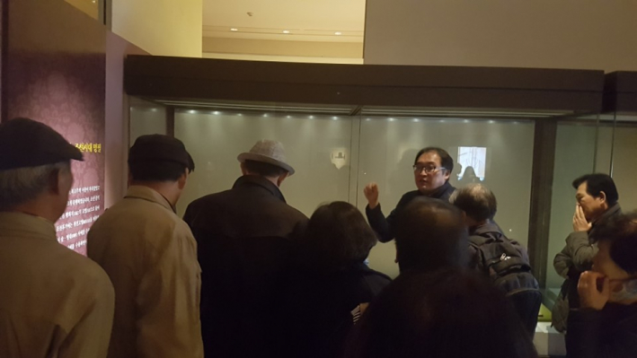 조선시대 명필을 관람하며 설명을 듣는 관람객들