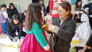 ‘우리옷나누미’ 회원들이 어린이들에게 직접 제작한 맞춤 한복을 입혀주고 있다.