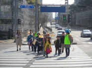 어린이 보행 안전 지도사가 아이들과 함께 횡단보도를 건너는 모습.