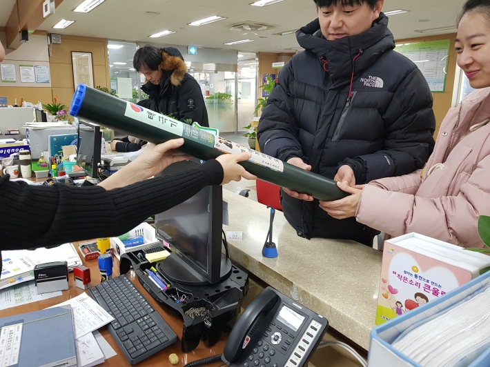 권선구청에서 혼인신고 한 부부가 태극기를 증정받고 있는 모습