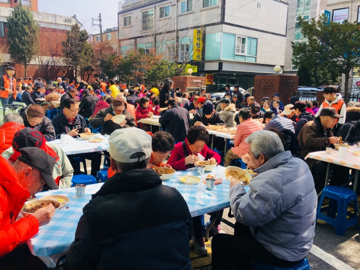 정자2동 정과사랑나눔회가 주최하는 짜장면데이에 기로경로당 앞마당에서 어르신들이 짜장면을 드시는 모습입니다.