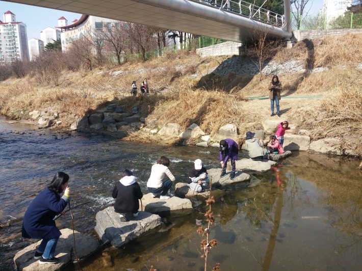 나무 막대기를 넣어 하천에서 들리는 물소리를 듣고 있다
