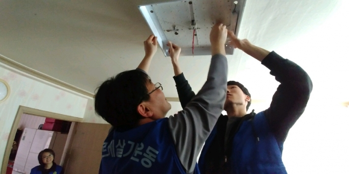 2018년 4월 9일 매탄2동 바르게살기위원회가 저소득 가구에 방문하여 일반등을 LED등으로 교체, 지원하고 있다.