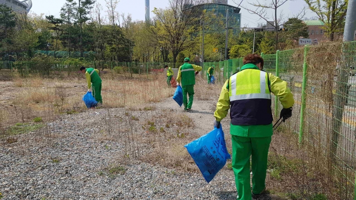영통3동 환경관리원이 국유 공한지를 청소하고 있다.