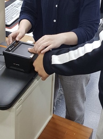 전자지문스캐너로 지문을 스캔하는 모습